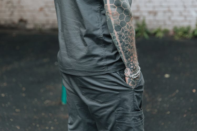 Person In Black Shirt And Pants With Arm Tattoo 