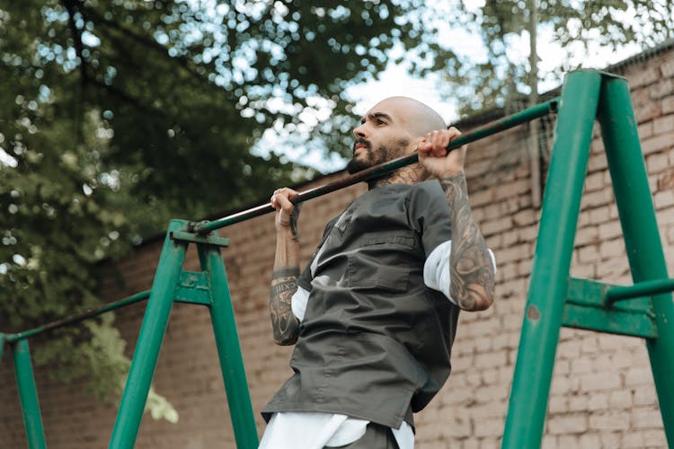 Man Lifting Himself On Outdoor Pull Up Bar