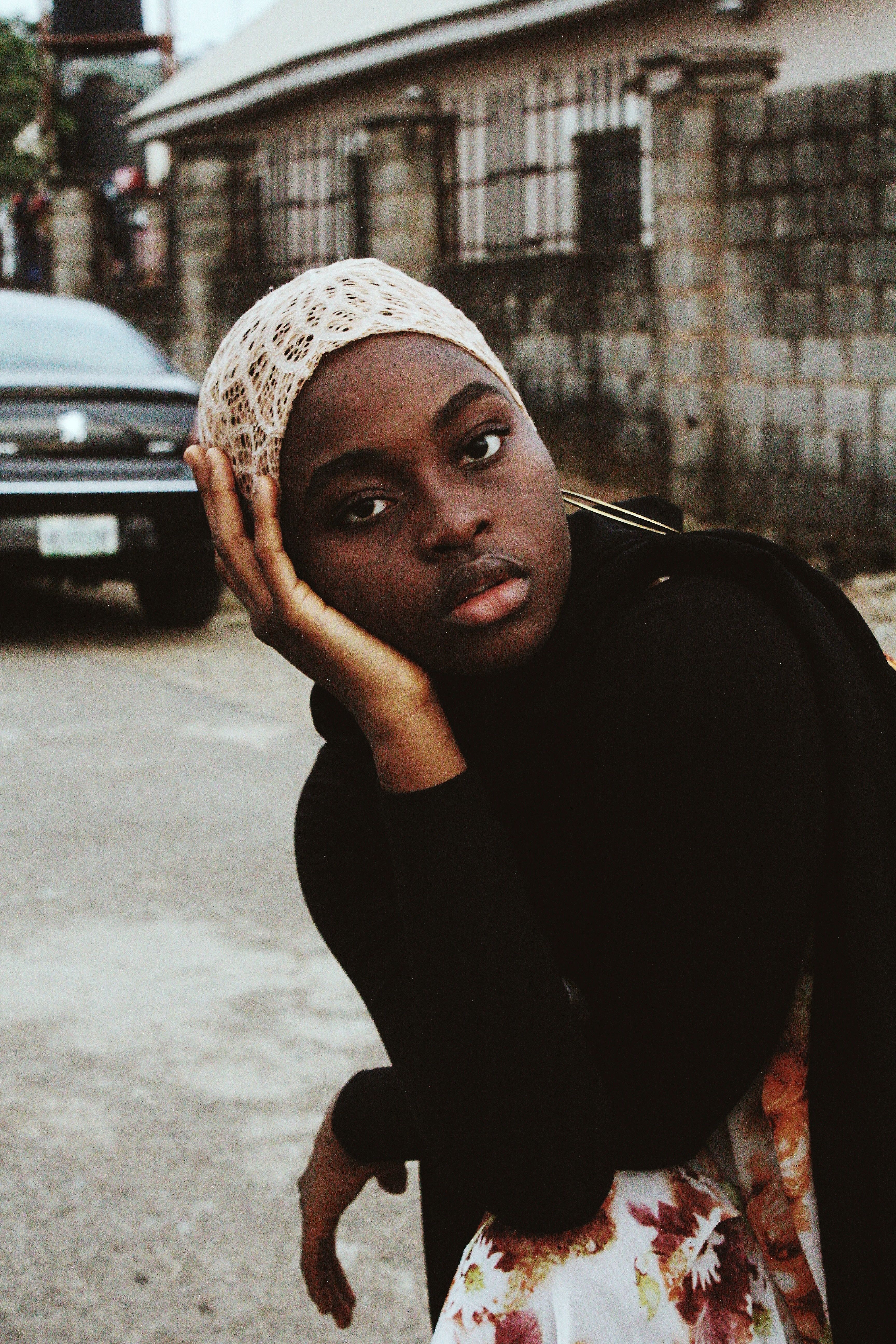 A reflective portrait of a woman in an urban Nigerian street setting. Ideal for diverse lifestyle themes.