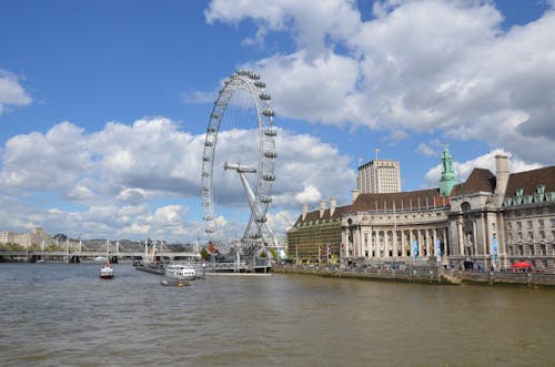 White Ferris Wheel Near the River and Concrete Buildings 