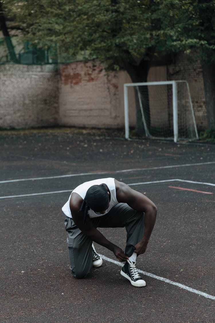 Man Tying Shoes On Sports Ground