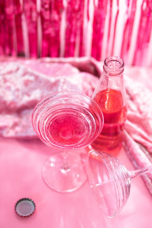 Clear Glass Bottle and Wine Glasses with Pink Liquid 