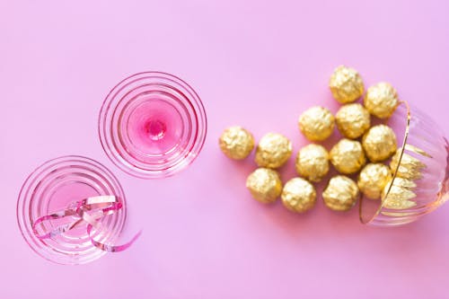 Glasses and Chocolates on Pink Background