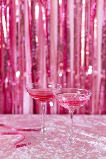 Chic pink cocktails on a glittery surface against a shimmering backdrop. Perfect for festive occasions.