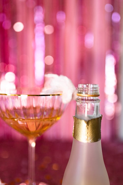 Clear Wine Glass next to a Bottle of Alcohol 