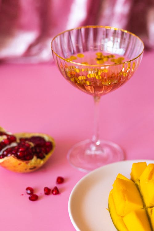 Clear Wine Glass With Pink Liquid and Gold Confetti 