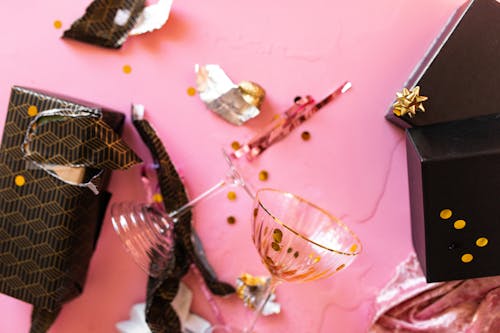 Gift Boxes and Wine Glass on Pink Surface