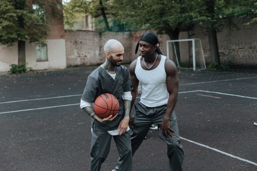 Free Two men playing basketball on an outdoor court, showcasing teamwork and energy. Stock Photo