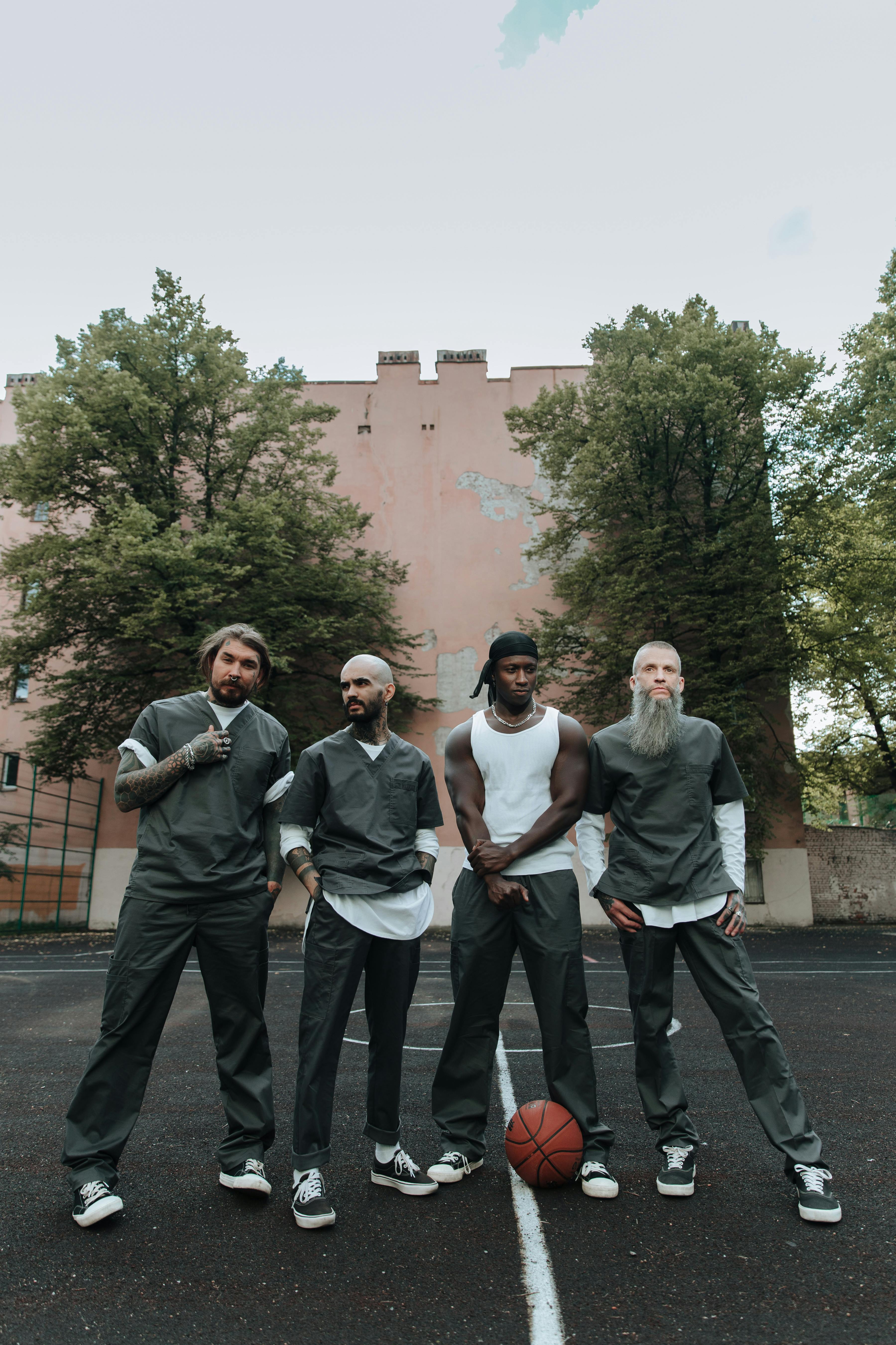 men wearing prisoner s uniform standing on a backyard basketball court