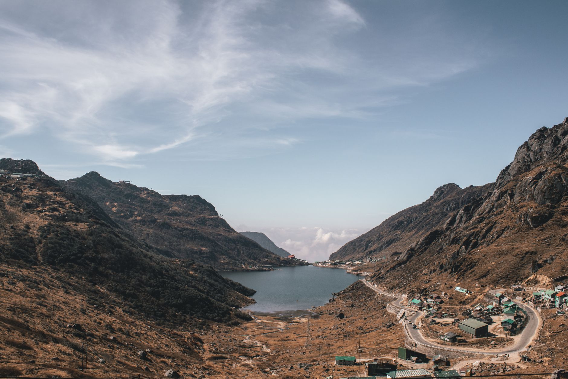 Scenic mountain lake surrounded by brown peaks in Sikkim