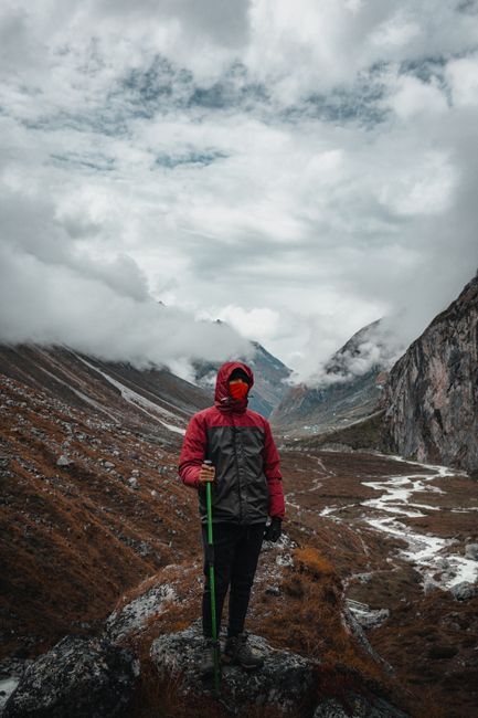 Hiker stands amidst stunning winter mountain landscape, exuding adventure and exploration.