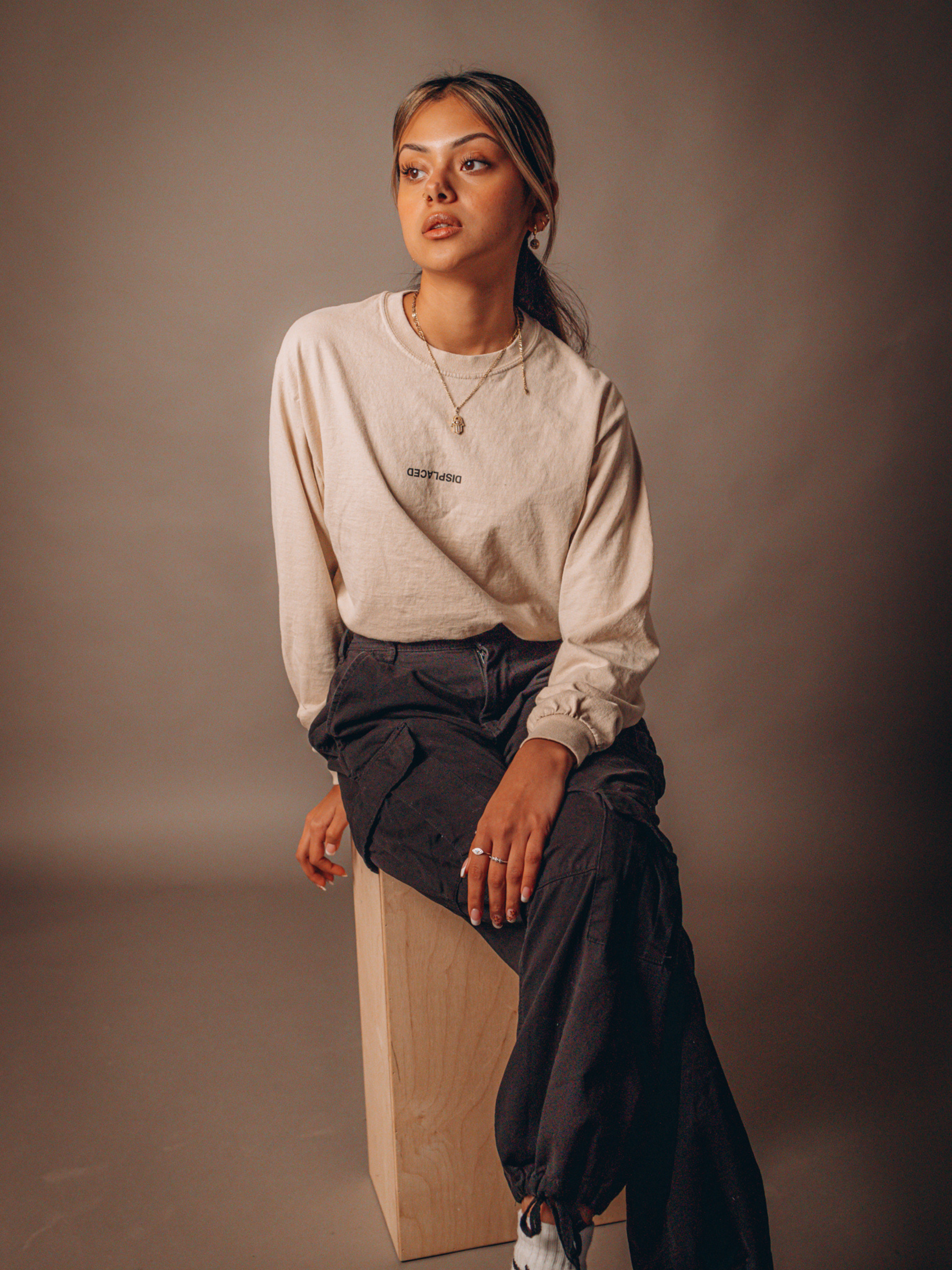 A Woman in Black Pants Sitting on a Wooden Block · Free Stock Photo