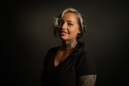 Free A Tattooed Woman in Black Shirt Smiling Stock Photo