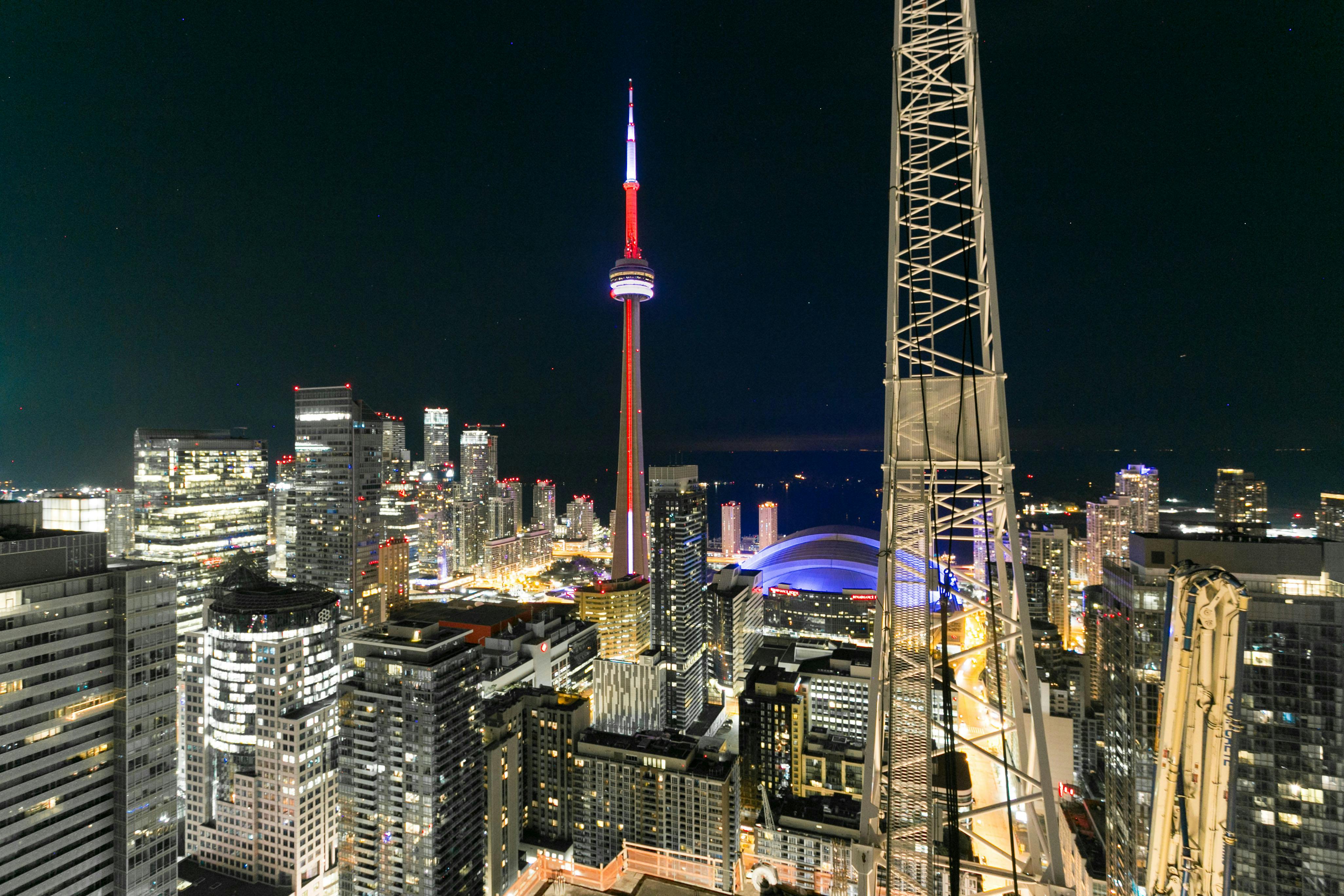 多伦多令人惊叹的夜间城市景观中，加拿大国家电视塔被照亮，展现了城市的建筑风貌