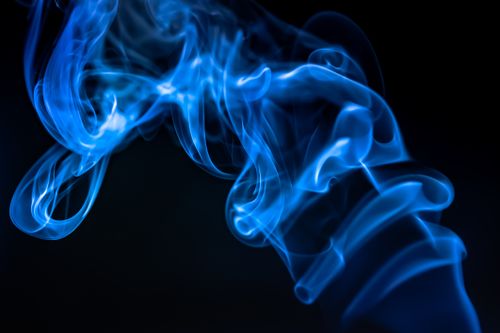 Free Vibrant blue smoke swirling against a dark backdrop, creating abstract patterns. Stock Photo