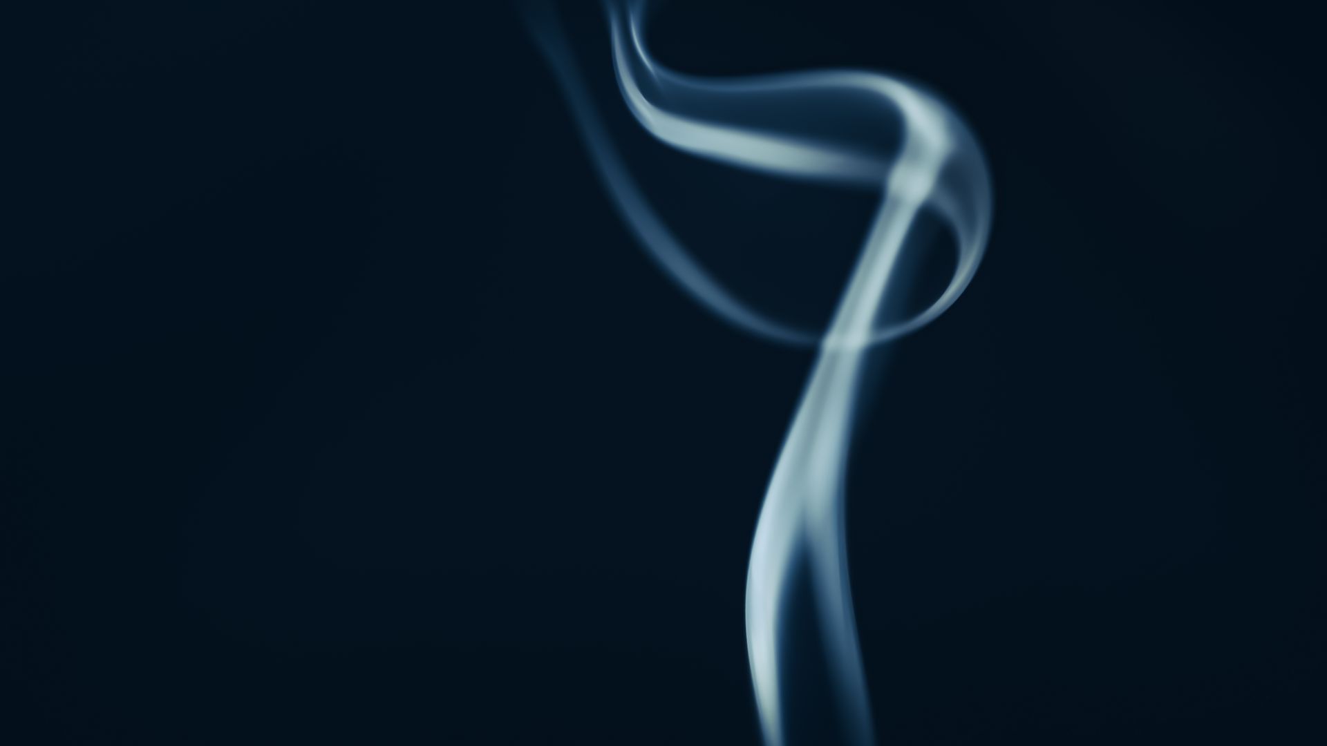 Elegant smoke swirl creating a mystical and artistic ambiance on a dark backdrop.