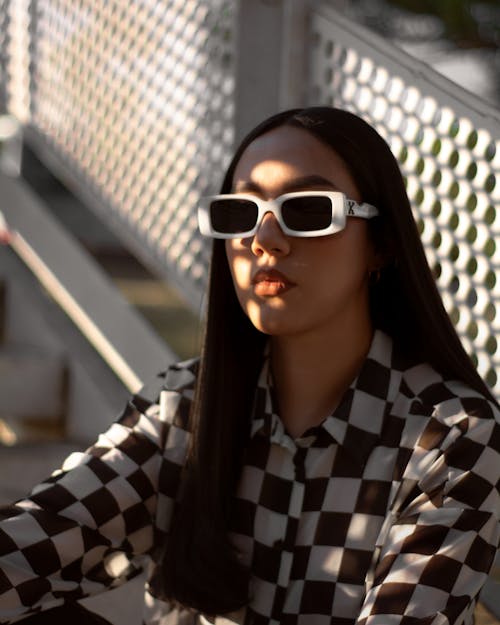 Woman in Checkerboard Print Long Sleeves Wearing White Framed Sunglasses