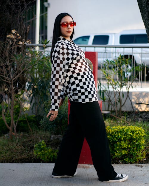 Woman in Black and White Checkered Long Sleeve Shirt and Black Pants