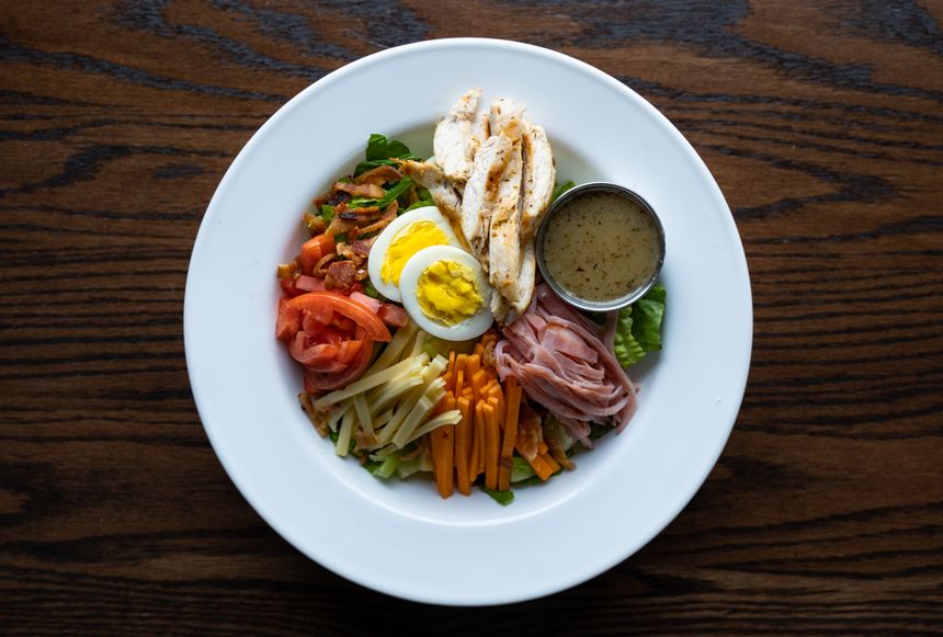 Overhead chopped salad with egg, tomato and greens on a ceramic plate — Alberta Studios on Pexels