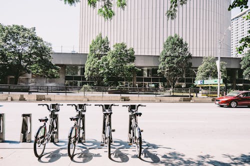 Four Black Parked Bicycles Near the Road