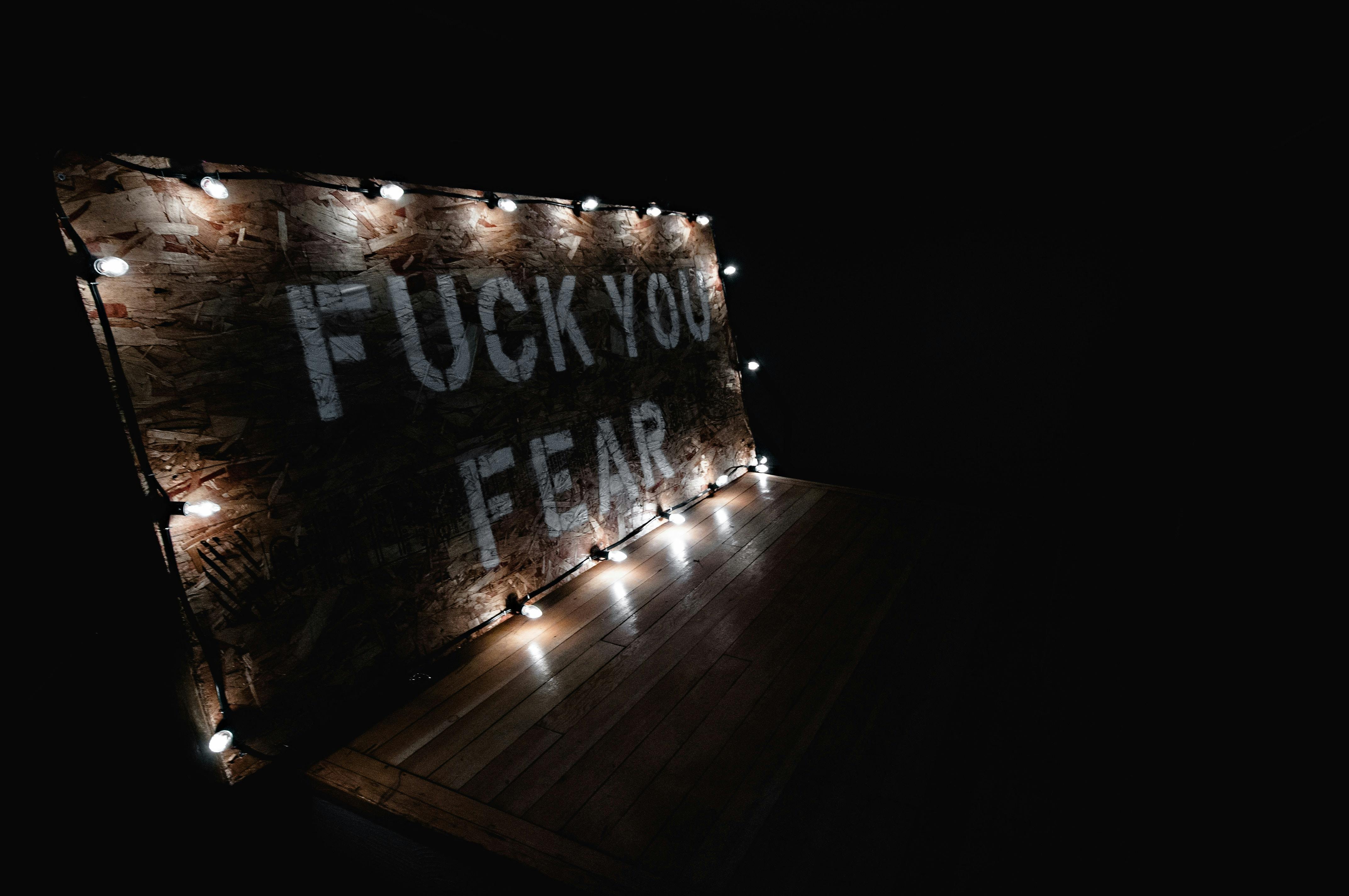 Fuck You Fear Text on Brown Wooden Wall · Free Stock Photo