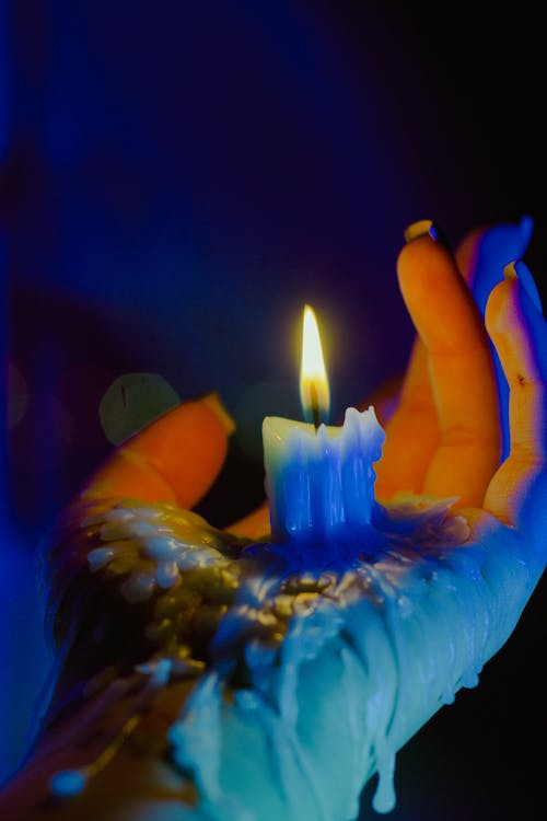 Close Up Photo of Lighted Candle on Person's Hand