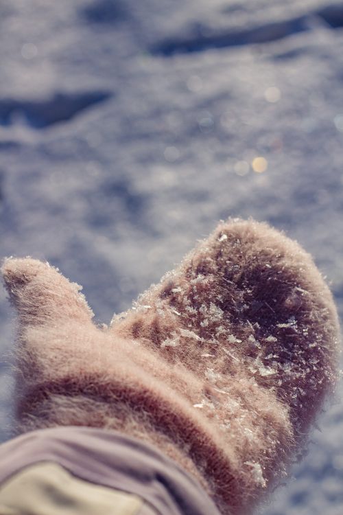 Free Close-up of wool mittens with snowflakes, capturing winter warmth. Stock Photo