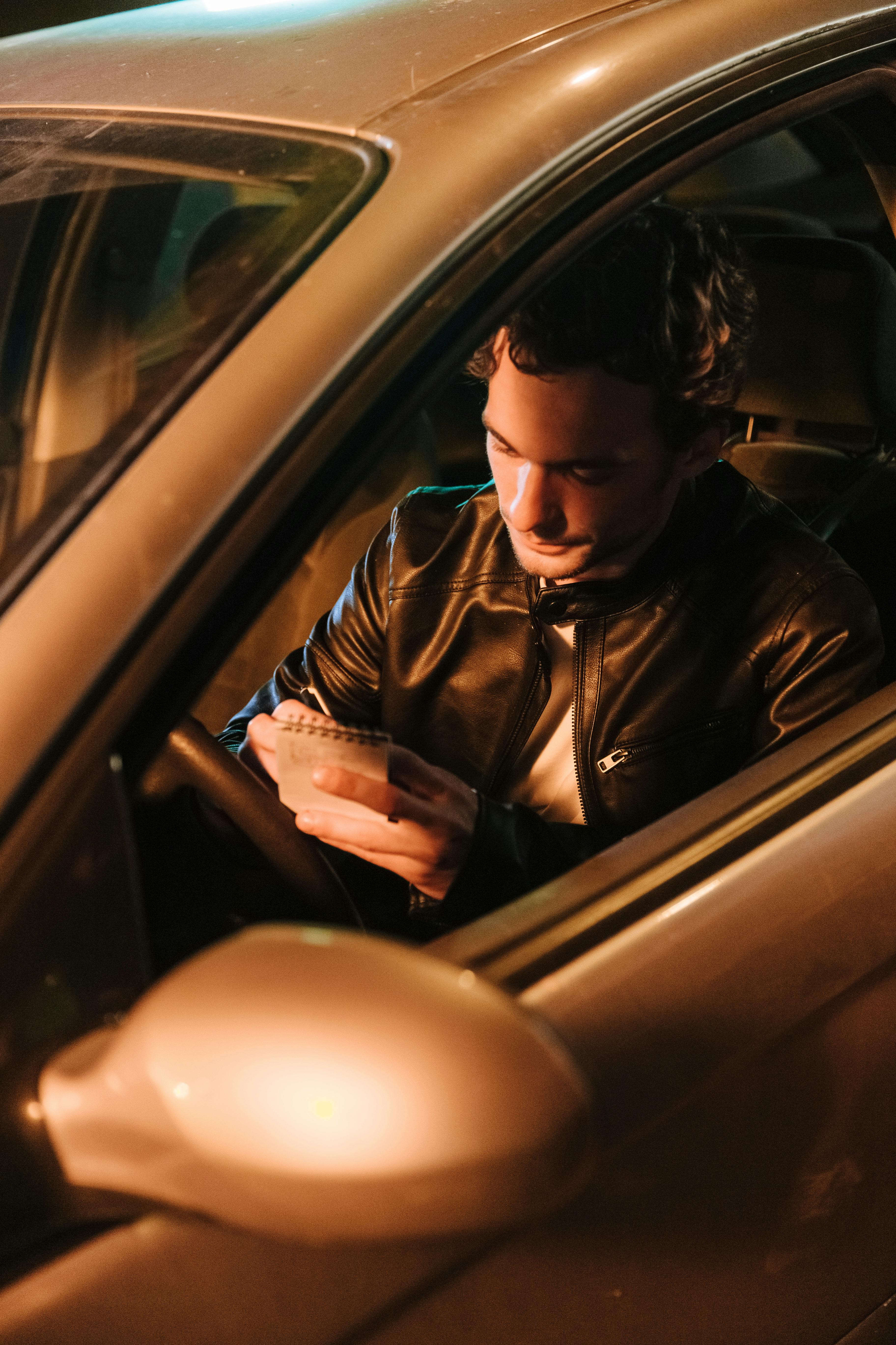 man making notes in car