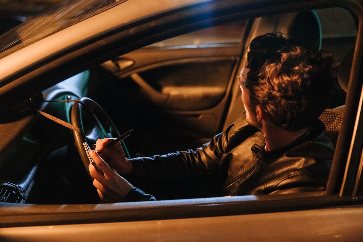 Reporter taking notes in a car at night