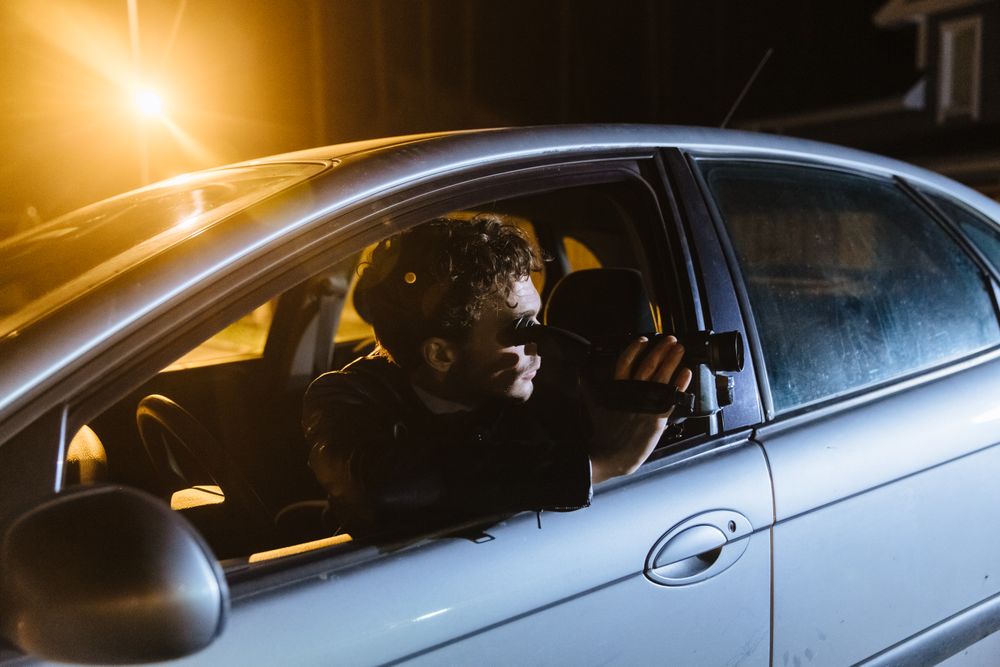 Investigator observing a street from inside a parked car at night