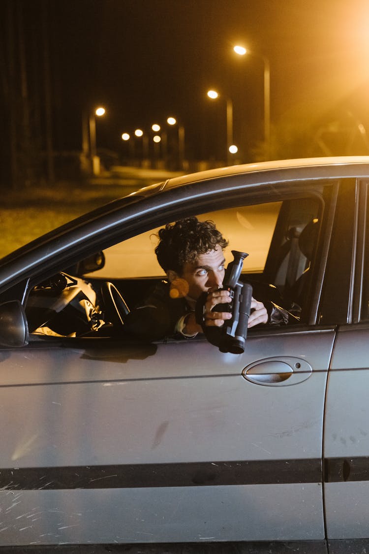 A Man Holding A Camera Inside The Car