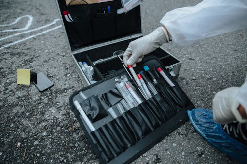 Close-up of a Crime Scene Investigator Taking a Tool out of a Box to Collect Evidence 