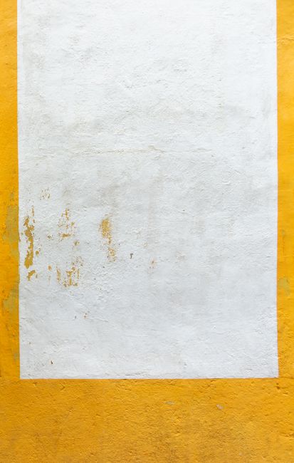 Close-up of a textured yellow and white wall in Valencia, Spain offering creative copyspace.