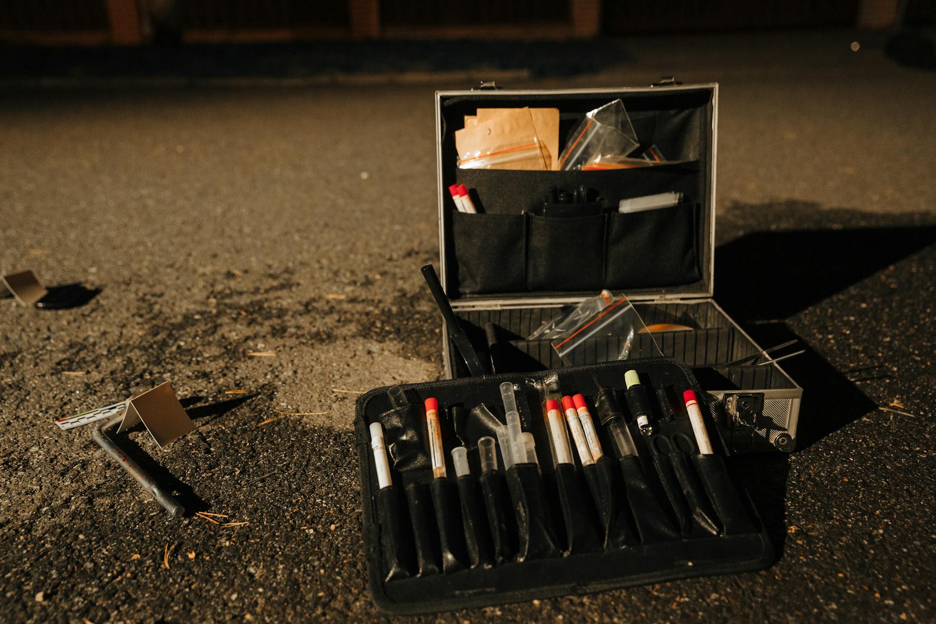 A forensic evidence kit on a road, capturing a crime scene investigation at night.