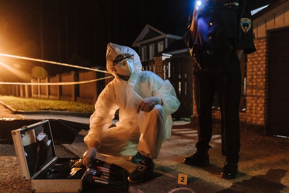 CSI team investigates a crime scene at night, using tools and flashlights for forensic analysis.