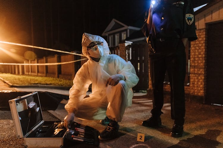 Forensics Investigator Talking To A Policewoman About The Found Evidence