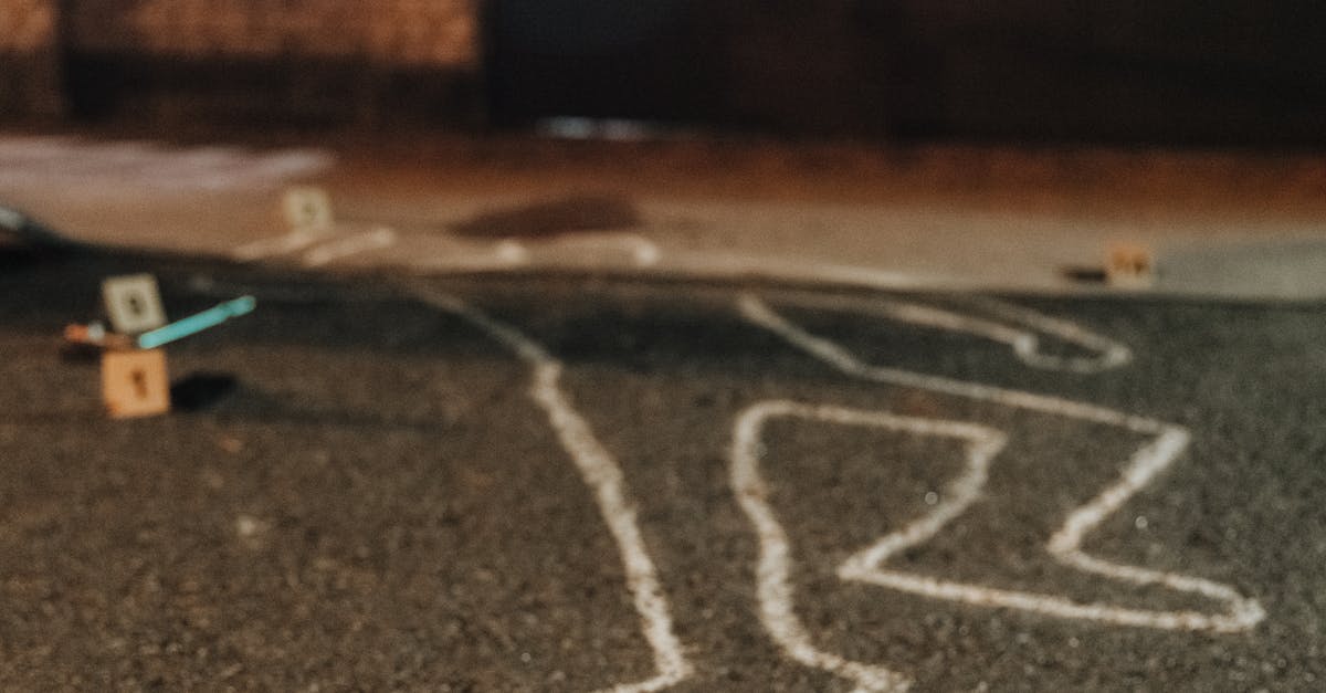 Photo by cottonbro studio Chalk outline and evidence markers at a crime scene outdoors at night.