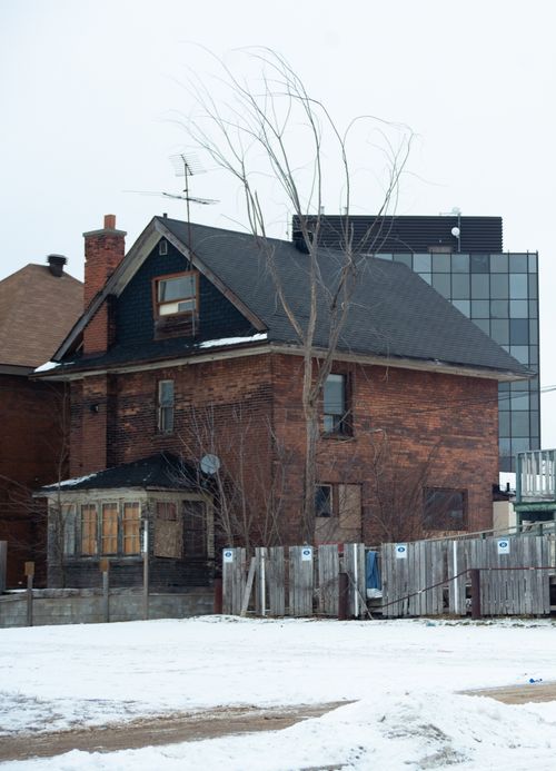 Free Winter urban landscape showcasing a snow-covered ground with a classic brick house in North Bay, Ontario. Stock Photo