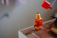 Orange Mini Toy on Brown Surface