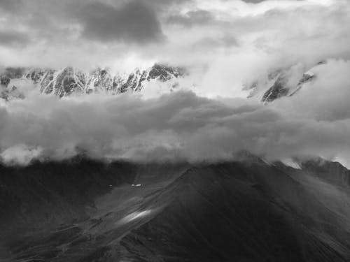 Free Grayscale Photo of Mountains Under the Cloudy Sky Stock Photo