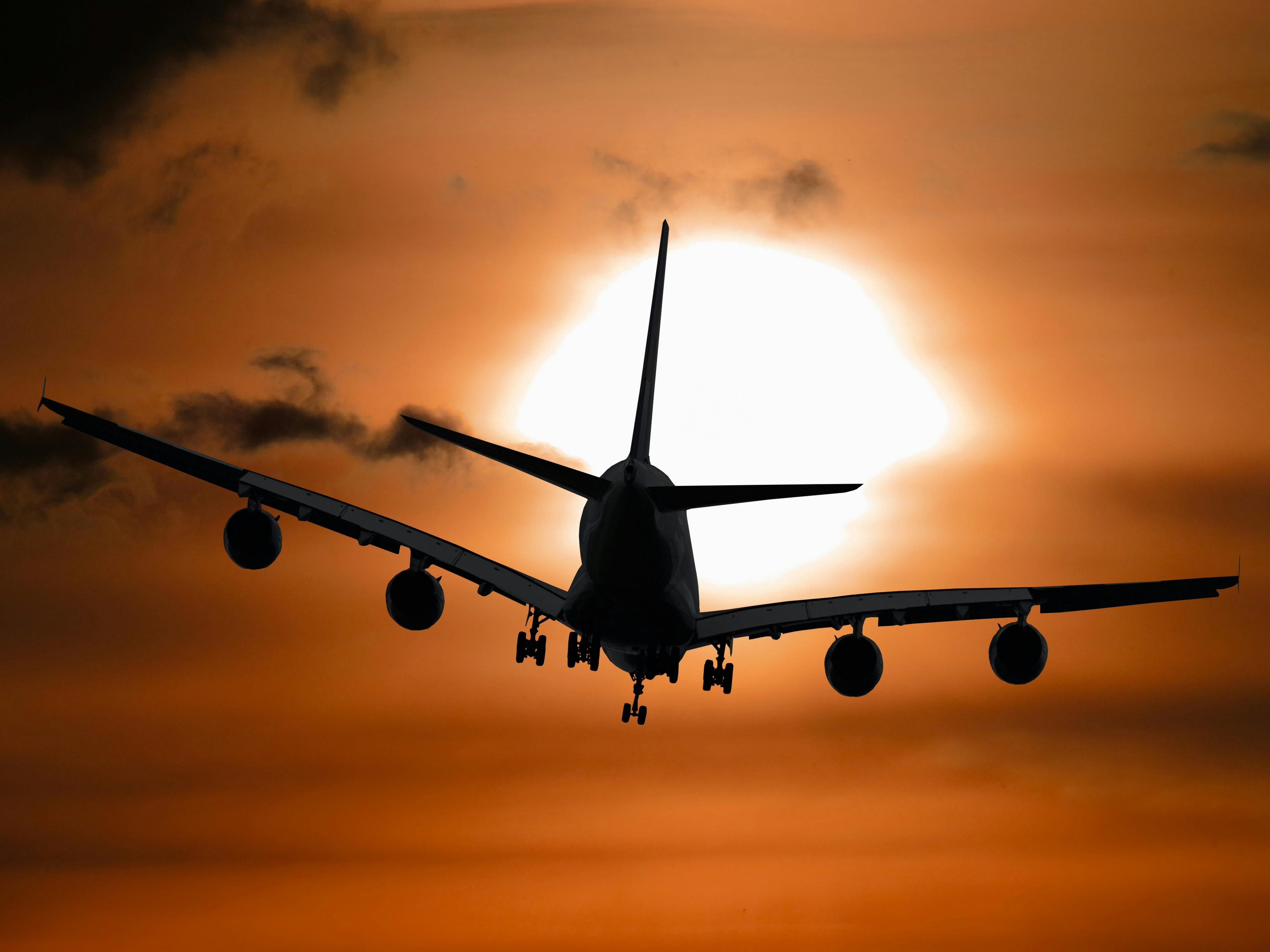 A plane flying during sunset. | Photo: Pexels