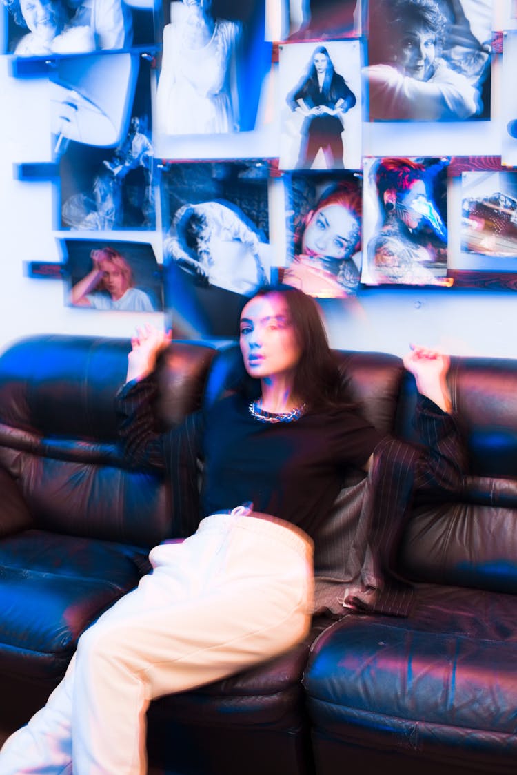 A Woman Sitting On Black Couch