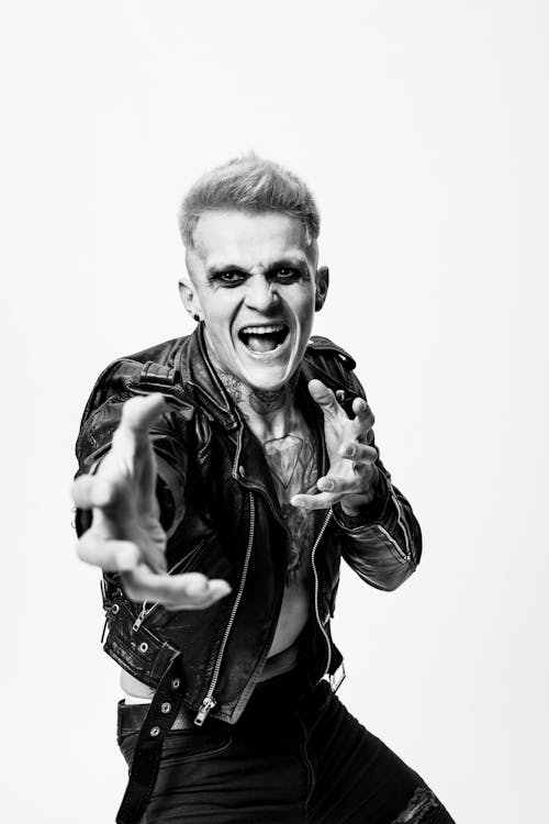 A Grayscale of a Tattooed Man Wearing a Leather Jacket