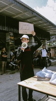 Man using megaphone for announcement at street market in Aceh, Indonesia. - Fotografer Sidoarjo
