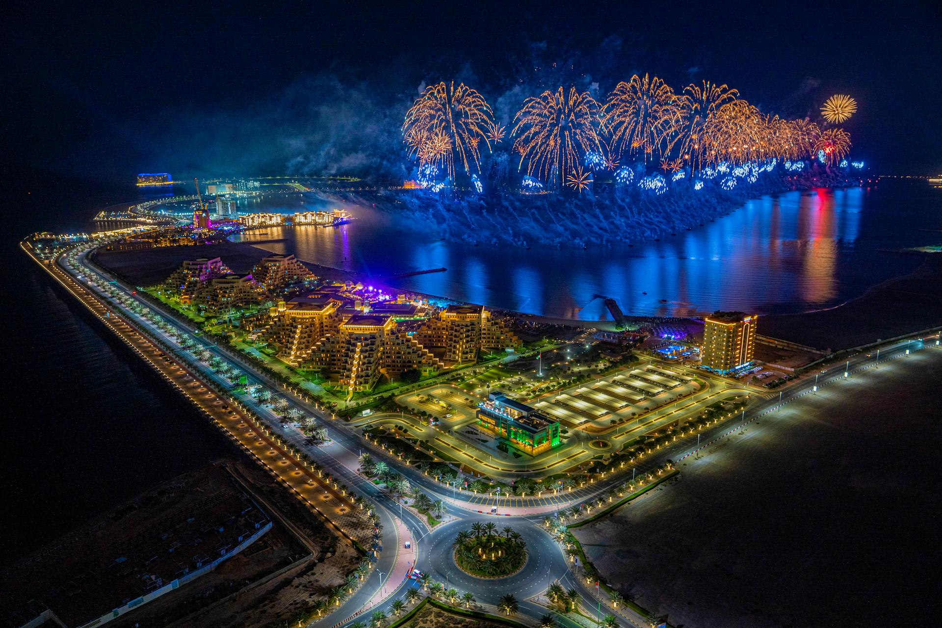 Breathtaking aerial view of fireworks over Ras al Khaimah coastline at night.