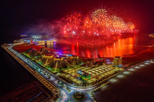 Free Aerial night view of fireworks over Ras Al Khaimah, UAE, illuminating the urban landscape with vibrant colors. Stock Photo
