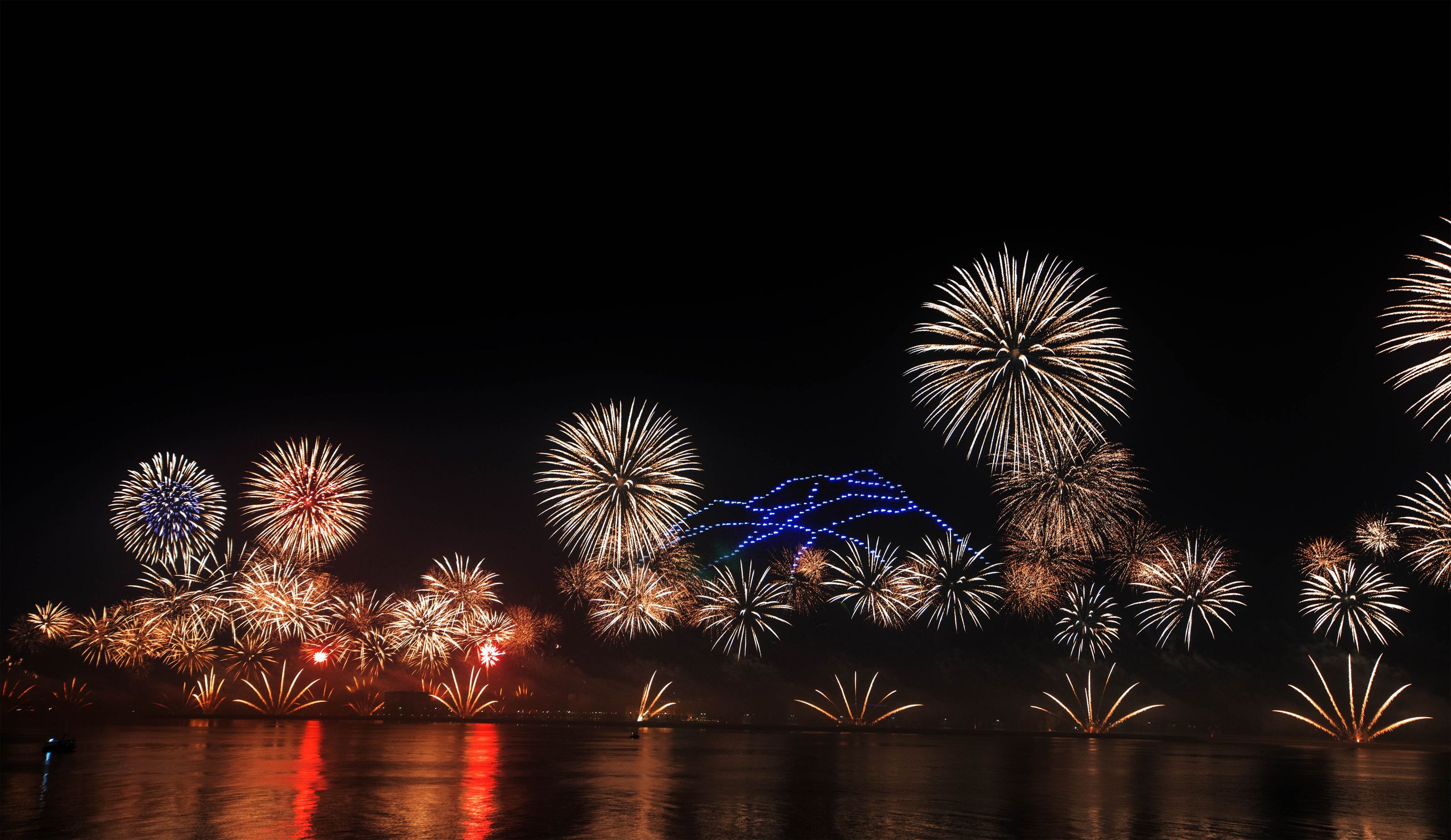 Feu d’artifice illuminant le ciel nocturne au-dessus de la mer
