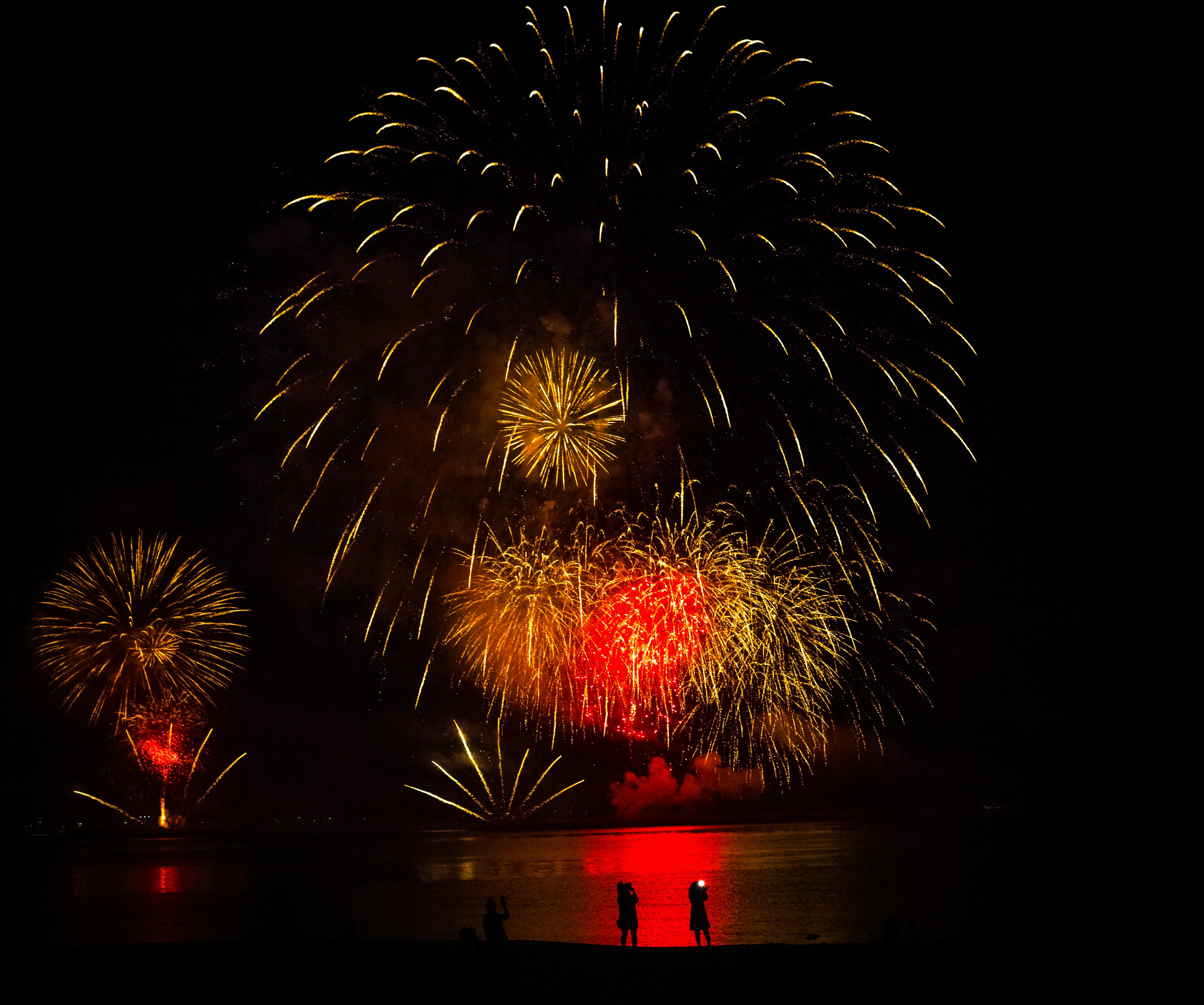silhouette of people under fireworks display