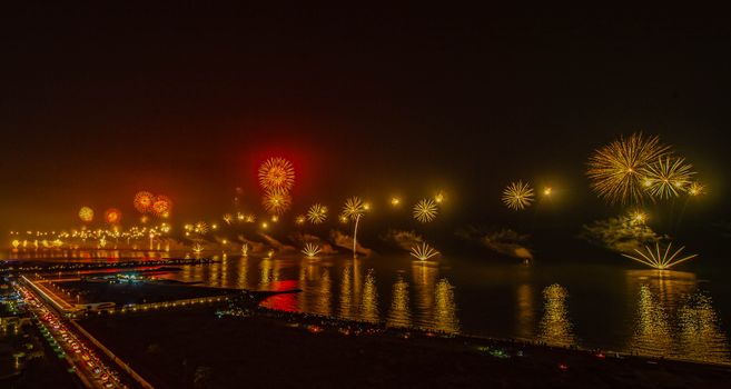 A vibrant fireworks show lights up the night sky over Ras Al Khaimah's waterfront.