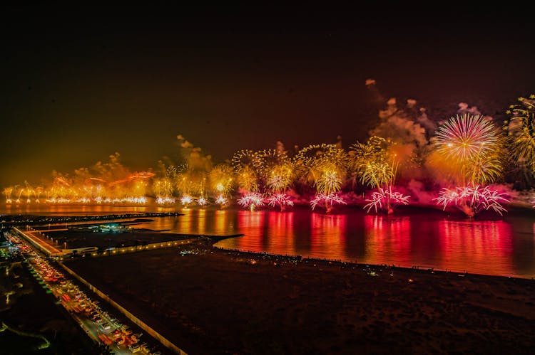 Colorful Fireworks At Sea Along A City